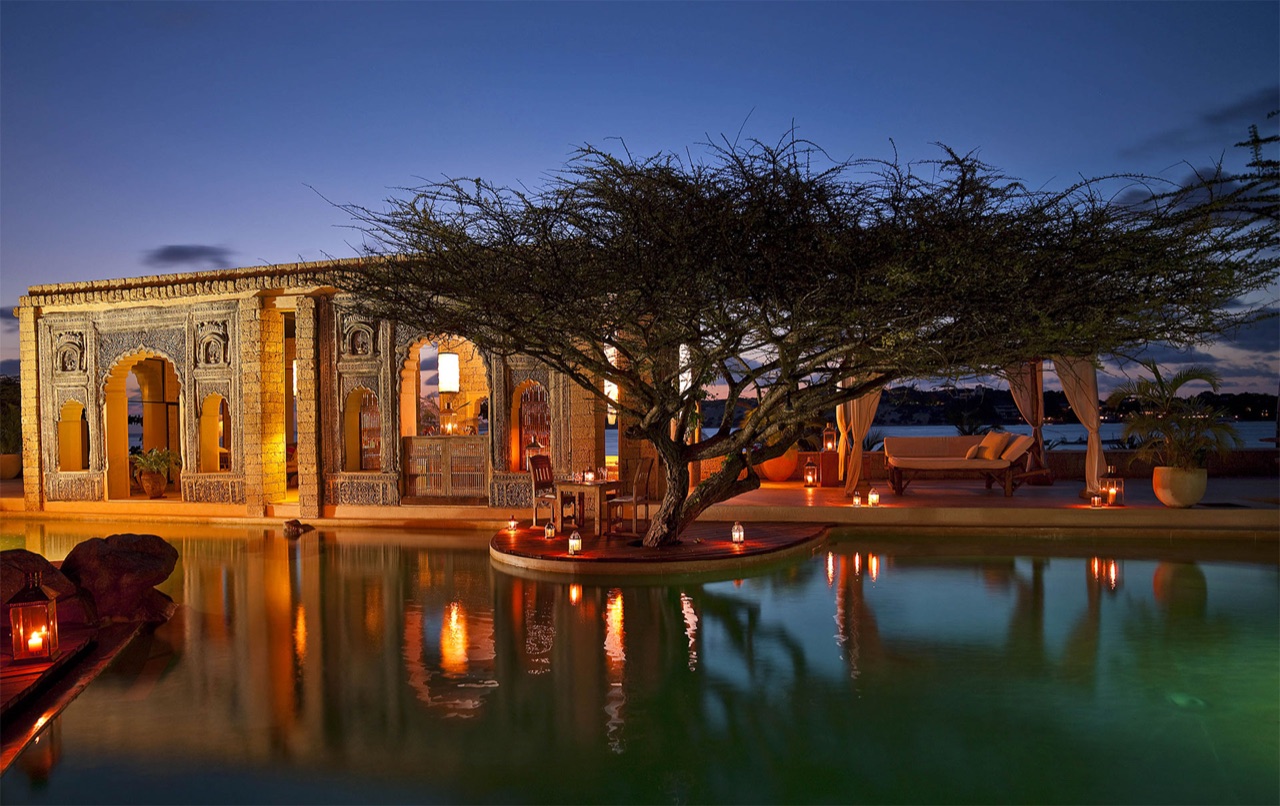 The Majlis villas glowing at dusk above the pool